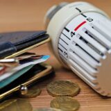 Heizkostenzuschuss, Thermostat und Geldbörse als Zeichen für gestiegene Heizkosten