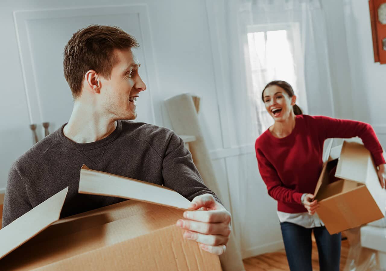 Wohnungsbauprämie - Glückliches Paar mit Umzugskartons zieht in neue Wohnung ein